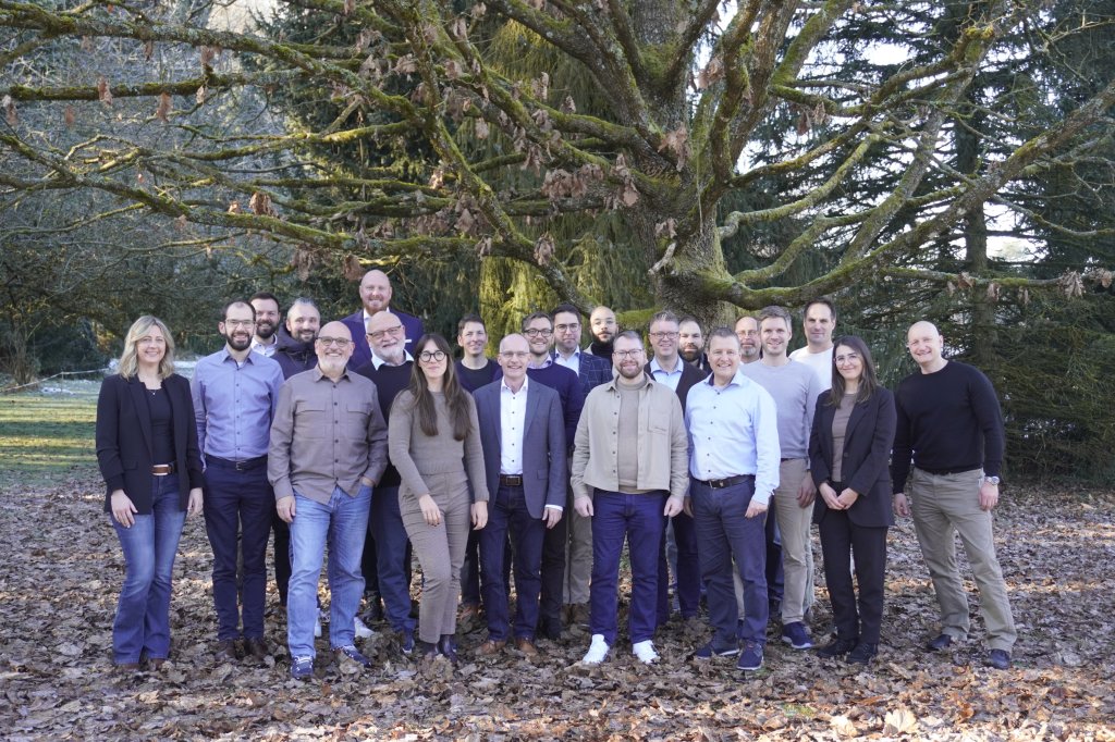 Eine Gruppe Mitarbeiter vor einem Baum.