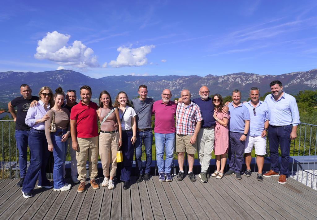Einige Mitglieder der internationalen ILD Group auf einer Terrasse vor den Bergen Sloweniens.